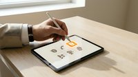 Man's hand with stylus selecting gold coin icon on digital tablet screen for financial app design, cryptocurrency, digital payment, and fintech development.