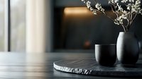 Minimalist still life with dried flowers in gray ceramic vase and cup on black stone plate against dark background, modern interior design styling.