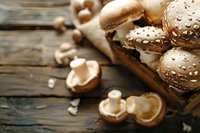 Fresh brown champignon mushrooms with water drops on rustic wooden background, raw organic food ingredients for healthy cooking and meal preparation.