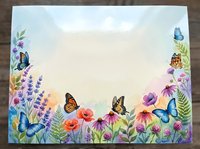 Watercolor floral border frame with colorful butterflies, wildflowers and blank center space for text or design on white background.