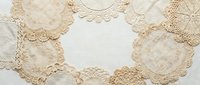 Vintage lace doilies arranged in circular pattern on white background. Delicate crochet textile elements for crafting, scrapbooking, wedding decor projects.
