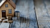 Wooden house model with stacked coins on rustic wood surface representing real estate investment, mortgage savings, property finance and home buying concept.
