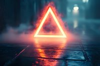 Glowing neon triangle frame floating above wet pavement in dark urban street with atmospheric fog and bokeh lights creating futuristic cyberpunk mood.