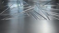 Abstract metallic surface with dynamic angular reflections and light streaks creating futuristic geometric patterns on brushed steel background.