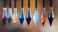 Colorful crystal pendulums hanging in row with gold caps against blurred background, mystical esoteric decoration for spiritual practices and divination.