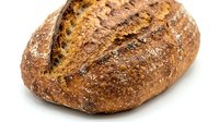 Freshly baked artisan sourdough loaf with crispy golden crust and flour dusting, isolated on white background for bakery, food, and culinary design use.