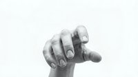 Newborn baby hand grasping adult finger in tender moment showing bond between parent and child in black and white photography for family concepts.