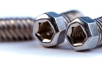 Close-up macro view of metal hex bolts with threaded interior showing industrial hardware details and mechanical engineering components on white background.
