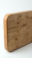Wooden cutting board with rounded edges and natural grain texture, isolated on white background for kitchen design, culinary content, and home decor projects.