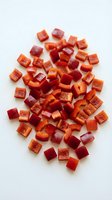 Fresh diced red bell peppers and onions chopped into small cubes on white background, ready for cooking and meal preparation in kitchen.