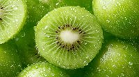 Fresh kiwi fruit slices with water droplets showcasing vibrant green flesh and seeds. Healthy tropical fruit background for nutrition and wellness concepts.