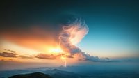 Dramatic lightning strike illuminates towering storm cloud during mountain sunset, creating ethereal glow against turquoise sky and layered mountain ranges.