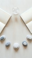 Minimalist spa wellness setup with smooth stones and wooden blocks arranged on light background for relaxation and meditation concepts.