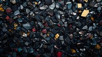 Dark scattered stones and colorful fragments create abstract mosaic pattern on black background, natural mineral texture for design and decoration.