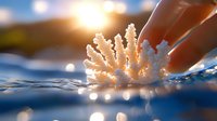 White coral piece touched by human hand at water surface with sunlight bokeh, symbolizing ocean conservation and marine life protection.