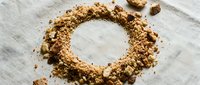 Ground cinnamon and nutmeg spices arranged in circular ring on white linen fabric, overhead view for culinary and cooking design projects.