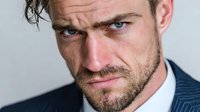 Professional businessman with beard and intense gaze in formal suit for corporate marketing and business presentations.