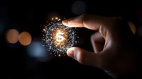 Glowing dollar symbol surrounded by sparkles and particles between fingers against dark background with bokeh lights, representing digital finance and wealth growth.