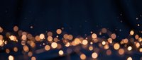 Abstract golden bokeh lights on dark blue background creating magical atmosphere for holiday celebrations and festive decorations.