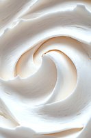 Creamy white meringue swirl texture with soft peaks and delicate curves creates an elegant abstract pattern for food and dessert backgrounds.