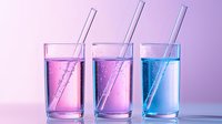 Three tall glasses filled with gradient pink and blue carbonated drinks with straws on pink background, modern minimalist beverage photography for menu design.