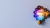 Glowing light bulb with colorful bokeh effect forming creative brain shape on gray background, symbolizing innovation and bright ideas in business concept.