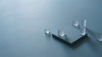 Minimalist geometric composition with white cubes arranged on dark platform against soft blue gradient background for modern design projects.