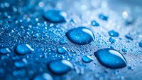 Water drops on blue metallic surface with bokeh effect and condensation creating natural pattern of scattered droplets. Macro photography showing surface tension.