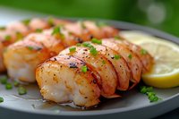 Grilled jumbo shrimp skewers with fresh herbs, spices and lemon garnish served on dark plate, close up view with selective focus and bokeh background.