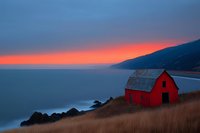 Red wooden barn on coastal cliff against dramatic sunset sky and ocean view, mountain silhouette in background, dry autumn grass in foreground creates rustic seascape.
