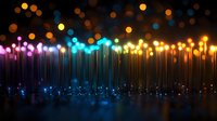 Glowing colorful light dots connected by vertical lines creating magical illuminated abstract background with bokeh effect in dark space. Futuristic design element.