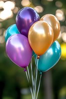 Festive bunch of metallic purple, gold and turquoise balloons floating against blurred bokeh background, creating celebratory party atmosphere.