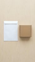 White envelope and brown cardboard box on beige background for business correspondence and shipping mockup design.