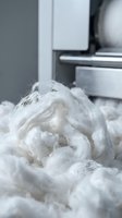 Fluffy white lint and fibers accumulate in dryer vent, showing need for cleaning and maintenance of household appliance.