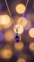 Silver necklace with teardrop amethyst pendant against warm bokeh lights. Elegant jewelry for special occasions, gifts, and luxury fashion styling.