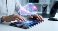 Professional using tablet with holographic cloud computing interface displaying data analytics and digital transformation technology in modern office.