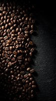 Roasted coffee beans scattered on dark slate surface with copy space for cafe menu design and beverage advertising.