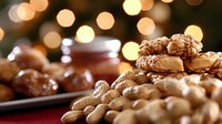 Festive holiday nuts and cookies arrangement with warm bokeh lights background, featuring walnuts, almonds and homemade baked treats for seasonal celebrations.