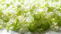 Fresh sliced green and white leeks or spring onions scattered on bright background with soft focus, macro photography for food industry and cooking blogs.