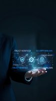 Businessman in dark suit holding glowing digital security interface with shield, checkmark, and lock icons representing trust verification, reliability, and cybersecurity solutions for business protection.