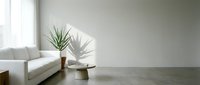 Minimalist living room interior with white sofa, potted plant, and concrete floor, ideal for home decor and interior design projects.