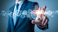 Businessman in suit touching digital technology interface with glowing gears and data icons representing automation and innovation concepts.