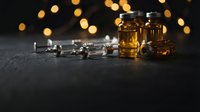 Whiskey glasses and corkscrew on dark surface with warm bokeh lights creating elegant bar atmosphere for luxury beverage photography and hospitality design.