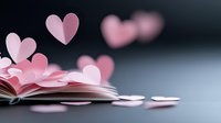 Pink paper hearts rising from open book pages against dark background, creating romantic atmosphere for valentines day cards and love stories.