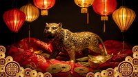 Golden ox statue standing among red silk cushions and gold coins with hanging red and gold lanterns on dark background, suitable for lunar new year celebrations and festive decorations.