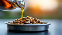 Pouring golden olive oil over roasted pine nuts in metal bowl against blurred warm sunset background, creating gourmet Mediterranean culinary scene.