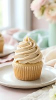 Vanilla cupcake with creamy frosting on ceramic plate, soft pastel table setting with flowers and natural window light for bakery and dessert designs.