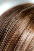 Close-up macro shot of straight brown hair strands showing texture and highlights, suitable for hair care products, beauty salon advertising and cosmetic marketing.