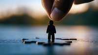 Small silhouette figure standing on puzzle piece held by giant hand against blurred nature background, representing personal growth and life challenges.