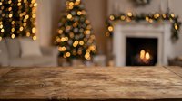 Rustic wooden table surface with blurred Christmas tree lights and cozy fireplace in background creating warm holiday atmosphere for product display.
